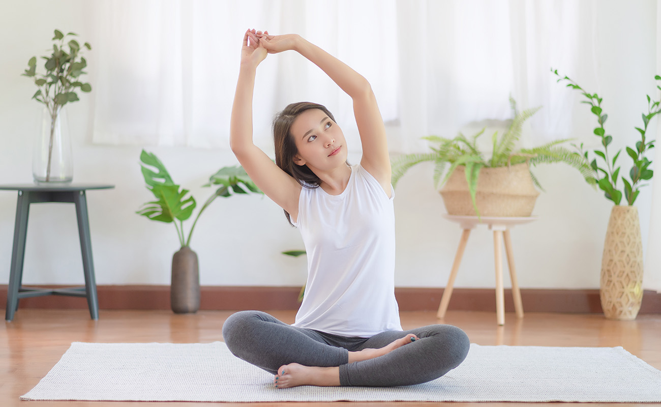 一名女子在家中做瑜伽運動，有助於緩解失眠問題。